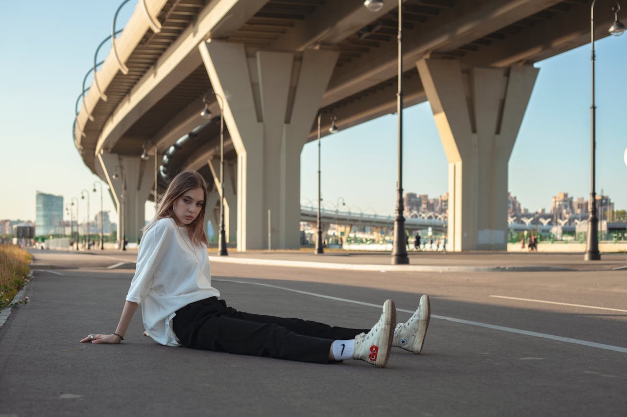 Crafting Captivating Headlines: Your awesome post title goes here Young woman in casual streetwear sitting under an urban overpass in daylight.